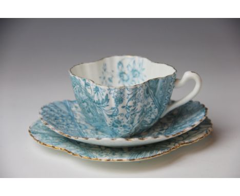 A Foley China, Wileman, Shelley trio, the quatrefoil shaped cup, saucer and side plate printed with a turquoise Aesthetic des