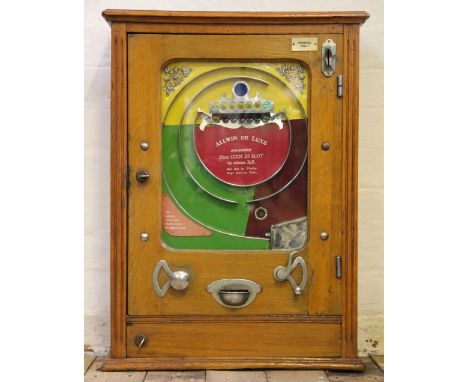 A 1940's Allwin de Luxe arcade penny slot machine, with coloured background and glazed door, in oak case