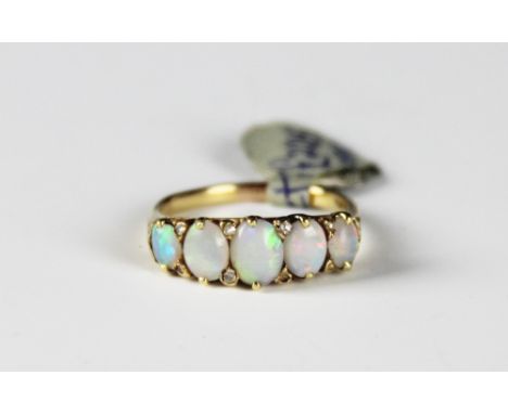 A late 19th/early 20th century Opal and diamond ring, the five graduated oval opals, interspersed with diamond set points, al