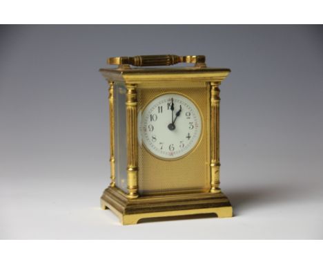 A late 19th century French lacquered brass carriage time piece, enamel Arabic dial within an engine turned brass mount, the c