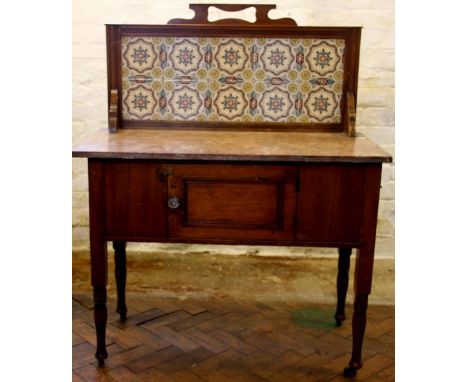 A Victorian pine marble top wash stand, with ten tile panel back, above a door, on turned legs, 114cm H x 90cm W x 46cm D