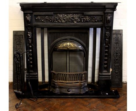 A modern cast iron fire surround, decorated with ferns, vines and vases of flowers, 110cm x 121cm, with a spark guard and a s