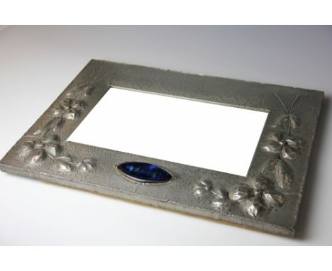 An early 20th century pewter mounted wall mirror, set with a blue enamel plaque and decorated in relief with flowers, 39cm H 