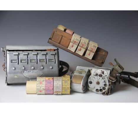 Two vintage bus ticket machines, with various ticket reels and a ticket rack