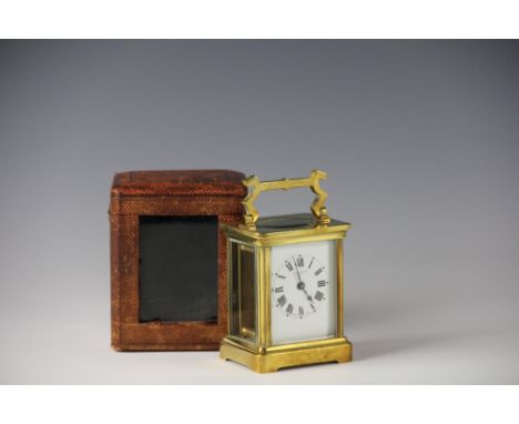 A lacquered brass carriage time piece, within original fitted leather effect case, the white enamel dial with black Roman num
