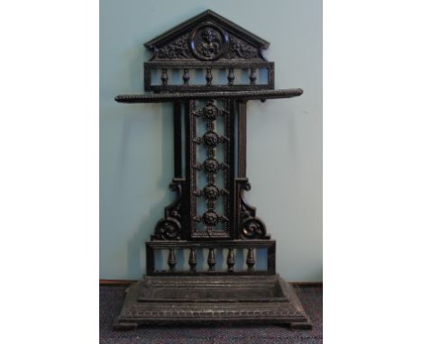 A Victorian cast iron stick stand, the arched top with a central portrait roundel, above a pierced back, on rectangular base,