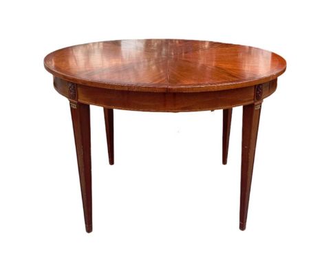 A Continental mahogany circular extending dining table on square tapering supports, 114 x 114cm when unextended, the circular
