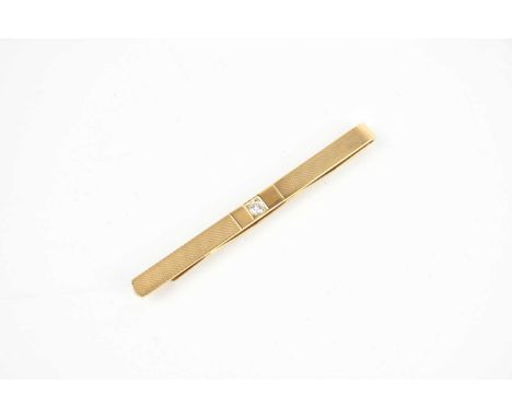A 9ct textured yellow gold diamond set tie clip, length 70mm, approx 7.4g.
