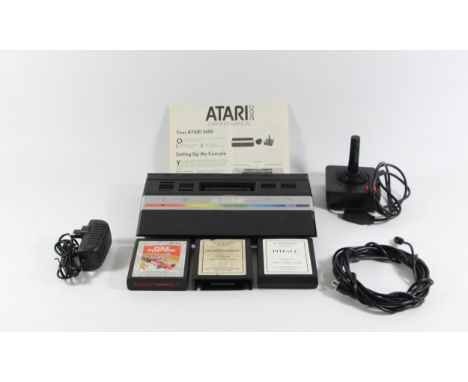 An Atari 2600 (serial No X717 3179349), power supply, AV cable, owners manual, joystick controller and three game cartridges,