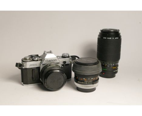 A Canon AE-1 35mm film camera, with three lens, including a Canon FD 28mm f2.8, Canon FD 50mm f1.8, Canon FD 75-200mm f4.5, w