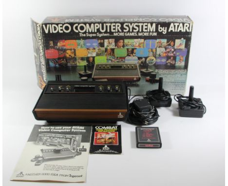 A boxed Atari 2600 'Woody' CX-2600U (serial No 548006420), original box, power supply, two paddle controllers, two joystick c