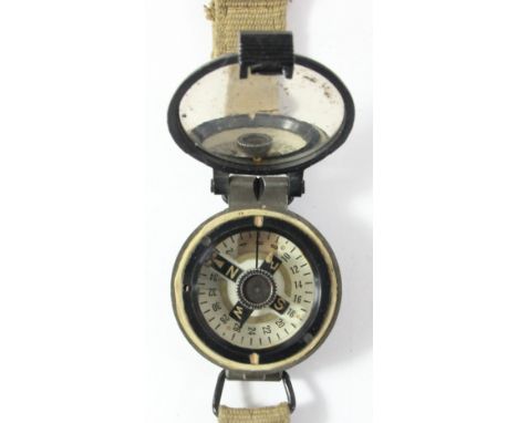 A British Army wrist compass, the hinged cover stamped B/132, Broad Arrow, Ref No 6B/2593, serial no 4828 RAA/5B A.G.I. Ltd, 