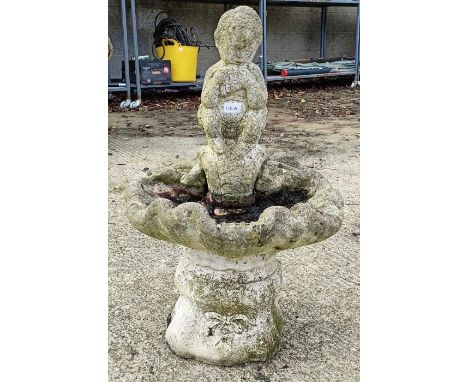 A stone figure playing pipes birdbath