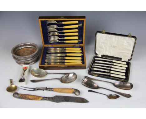 A pair of silver plated bottle coasters with turned wooden bases, a silver mounted carving knife and fork, along with a selec