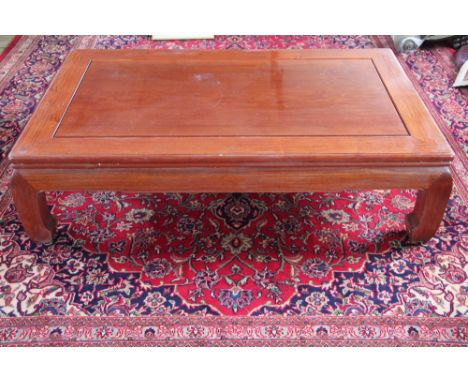 A Chinese hardwood low coffee table, with panelled top on scroll legs, 41cm H x 155cm W x 93cm D