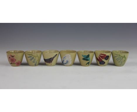 Seven Moorcroft egg cups, each decorated with a flower, bird or insect, against a drab ground, impressed marks, 4.5cm high (7