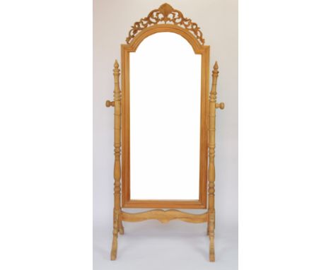 A modern pine cheval mirror, with turned uprights, on carved scroll legs, 190cm
