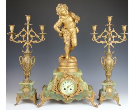 A 19th century French gilt spelter and onyx clock garniture, the clock with painted Arabic dial surmounted by a figure emblem