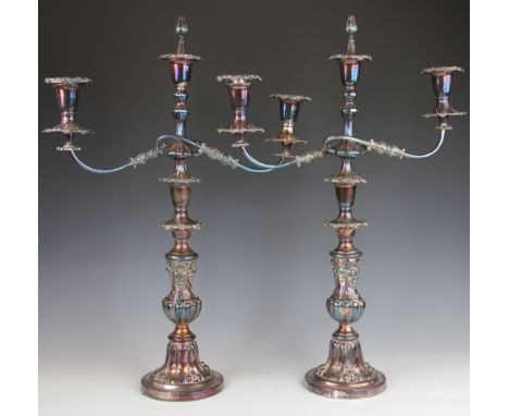 A pair of late Victorian silver plated three branch candelabra, each with two serpentine sconce arms, on a stem cast with fru