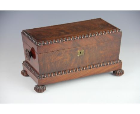 A Regency mahogany tea caddy, with turned side handles and beaded edges, on gadrooned bun feet, the interior with two caniste