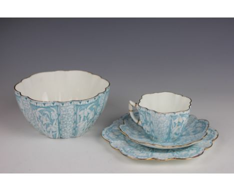 A Foley Chine Wileman Shelley trio, decorated with panels of snowdrops in pale blue, pattern 9180, with a matching slop bowl,