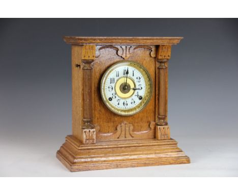 A late Victorian oak mantle clock with enamel Arabic dial and movement striking on a gong, 40cm