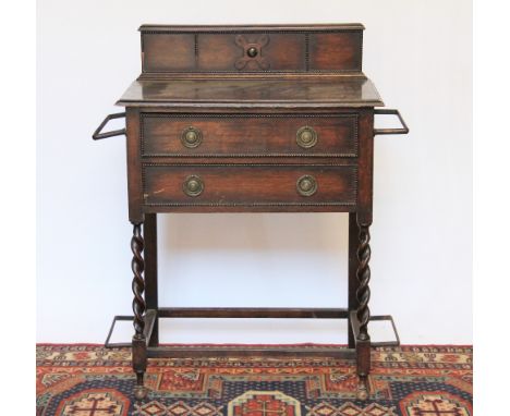 A 1920's oak hall table with, barley twist supports and integral stick stands, 87cm H x 70cm W x 37cm D