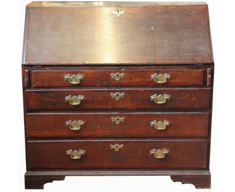 A George III oak bureau, with fall enclosing a boxwood inlaid fitted interior, over four graduated long drawers on bracket fe