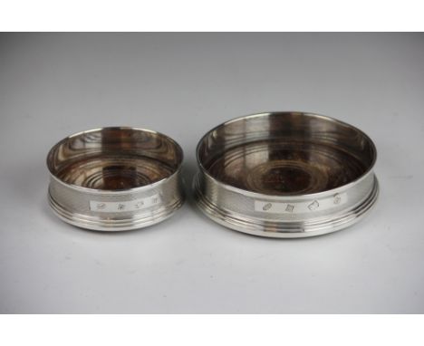 A silver bottle coaster W I Broadway & Co, Birmingham 1984, with engine turned detail and turned wooden base 12.5cm diameter 