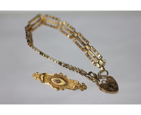 A 9ct gold three bar gate bracelet with attached padlock clasp and a Victorian brooch with central ruby stamped '9ct', total 