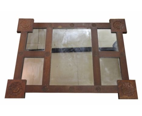 An Edwardian Arts and Crafts carved oak wall mirror, decorated with fourteen Tudor roses, 77cm x 105cm