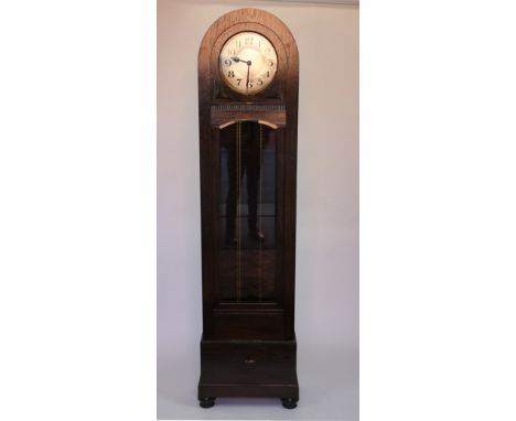 A 1920's oak longcase clock, with domed top and circular dial with Arabic numerals and movement striking on four gongs, with 