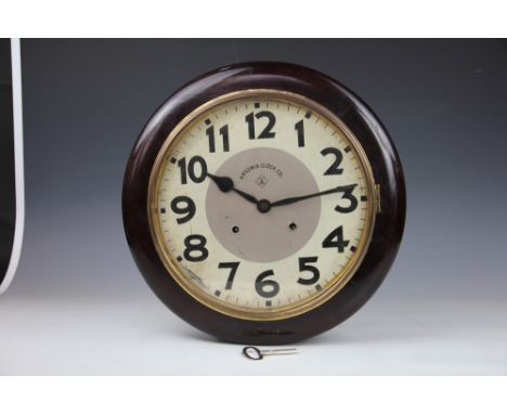 An American Ansonia Clock Co wall clock, with 29cm dial and movement striking on a gong, in stained wood case