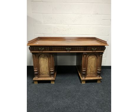 A late nineteenth century walnut twin pedestal desk fitted with three drawers