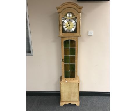 A blond oak Tempus Fugit longcase clock with pendulum and weights