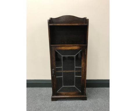 An oak leaded door cabinet fitted a shelf above