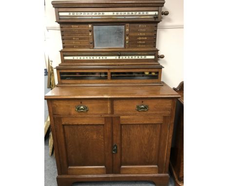 A late Victorian oak snooker score board cabinet, the score board area above cupboard base, fitted with two drawers, width 11