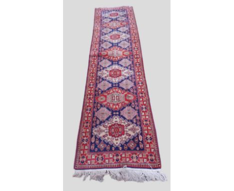 A North west Persian woollen runner with an all over design upon a blue, red and cream ground within multiple borders, 360cms