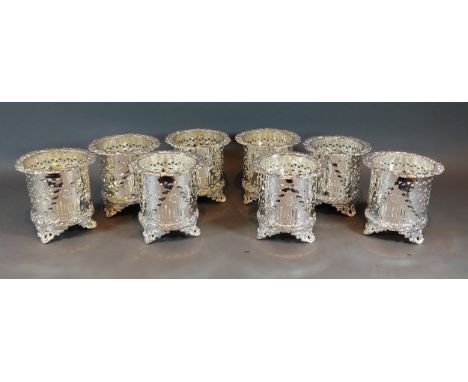 A set of eight silver plated bottle stands of embossed pierced form 