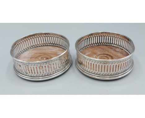 A pair of London silver bottle coasters of pierced form, 9.5cms diameter 