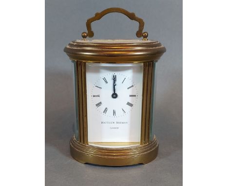 An oval brass carriage clock by Matthew Norman wthe lever escapement, 12cms tall 