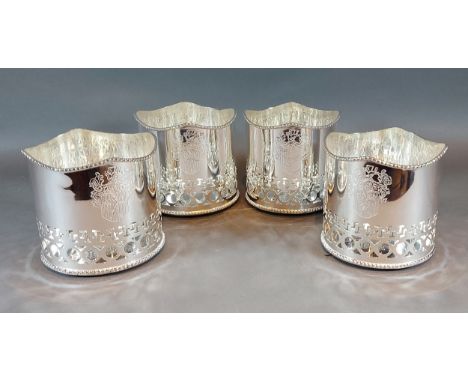 A set of four silver plated bottle coasters of pierced form 