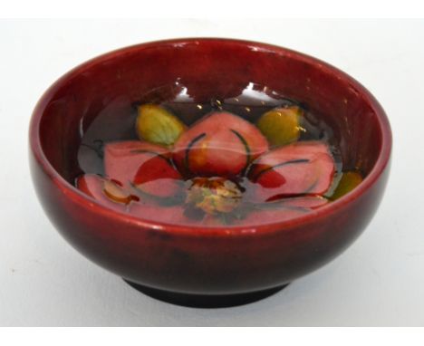 Walter Moorcroft - Flambe Clematis - A small footed bowl decorated with a tubelined flower and foliage against a tonal red gr
