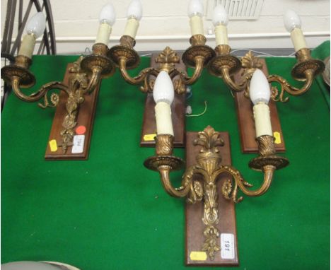 A set of four gilt twin branch wall light fittings
