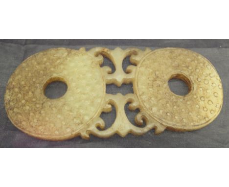 A 19th Century carved jade buckle, the two pierced disc ends with textured surface fixed between pierced decoration CONDITION
