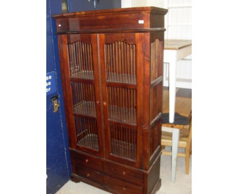 A modern Eastern cabinet with two doors enclosing three shelves, above four short drawers, raised on bracket feet