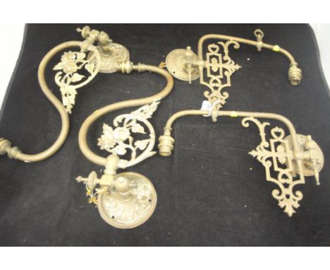 Two pairs of brass single branch wall light fittings, one with a flower on a branch decoration