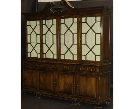 A Portuguese mahogany breakfront display cabinet with swan neck moulded pediment over four astragal glazed doors enclosing ad