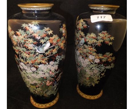 A pair of Meiji Period Japanese cloisonne vases decorated with finches amongst autumnal foliage and flowering plants on a dar