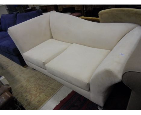 A modern cream upholstered two seat sofa with shaped back, raised on tapered metal legs